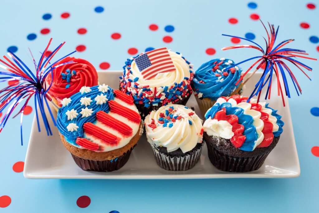 Festive cupcakes decorated with American flag themes and patriotic colors.
