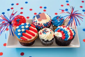 Festive cupcakes decorated with American flag themes and patriotic colors.
