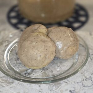 Two round, beige mushrooms on a clear glass plate.