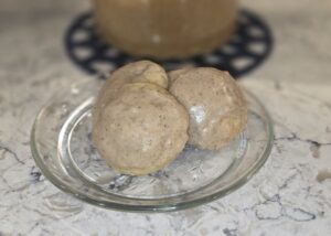 Two round bread rolls on a glass plate.