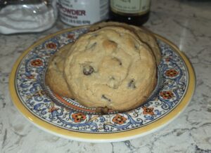 A large chocolate chip cookie on a decorative plate.