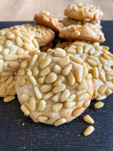 Close-up of pine nut cookies with a golden-brown crust.