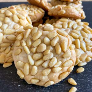 Close-up of pine nut cookies with a golden-brown crust.