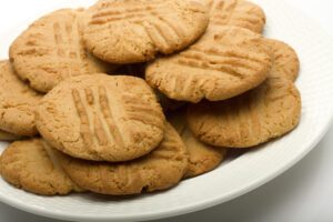 A plate of golden peanut butter cookies with fork marks.