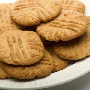 A plate of golden peanut butter cookies with fork marks.