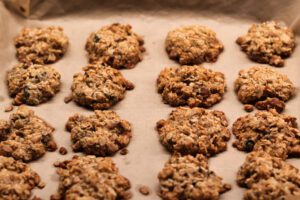 Freshly baked oatmeal cookies cooling on parchment paper.
