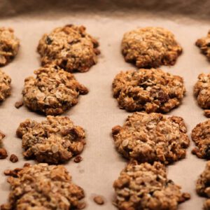 Freshly baked oatmeal cookies cooling on parchment paper.