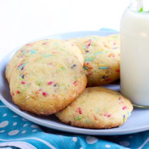 Plate of colorful confetti cookies with a glass of milk.