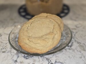 Two large, soft cookies on a glass plate.