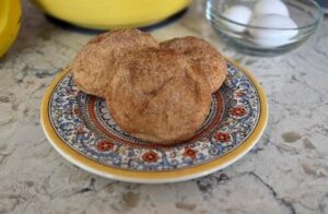 Two cinnamon sugar-coated pastries on a decorative plate.
